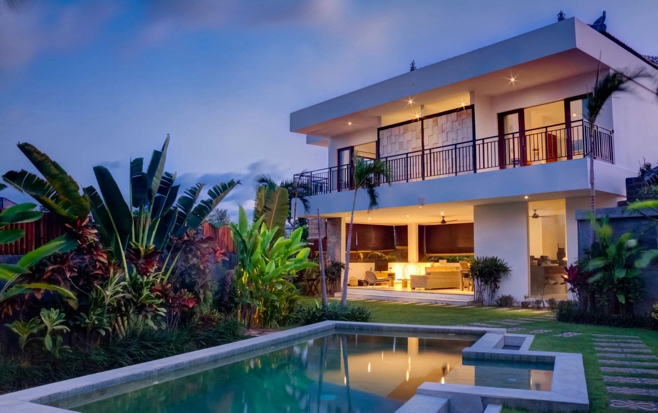 A large white house with a pool in the middle of it.